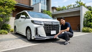 モデリスタエアロを装着したパールホワイトのアルファードのフロントスポイラー横にしゃがみ地上高を確認する若い日本人男性