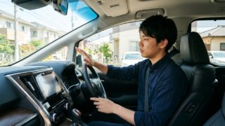 ヴェルファイアの運転席でエアコン吹き出し口からの酸っぱい臭いに気づき点検を考える若い日本人男性オーナー